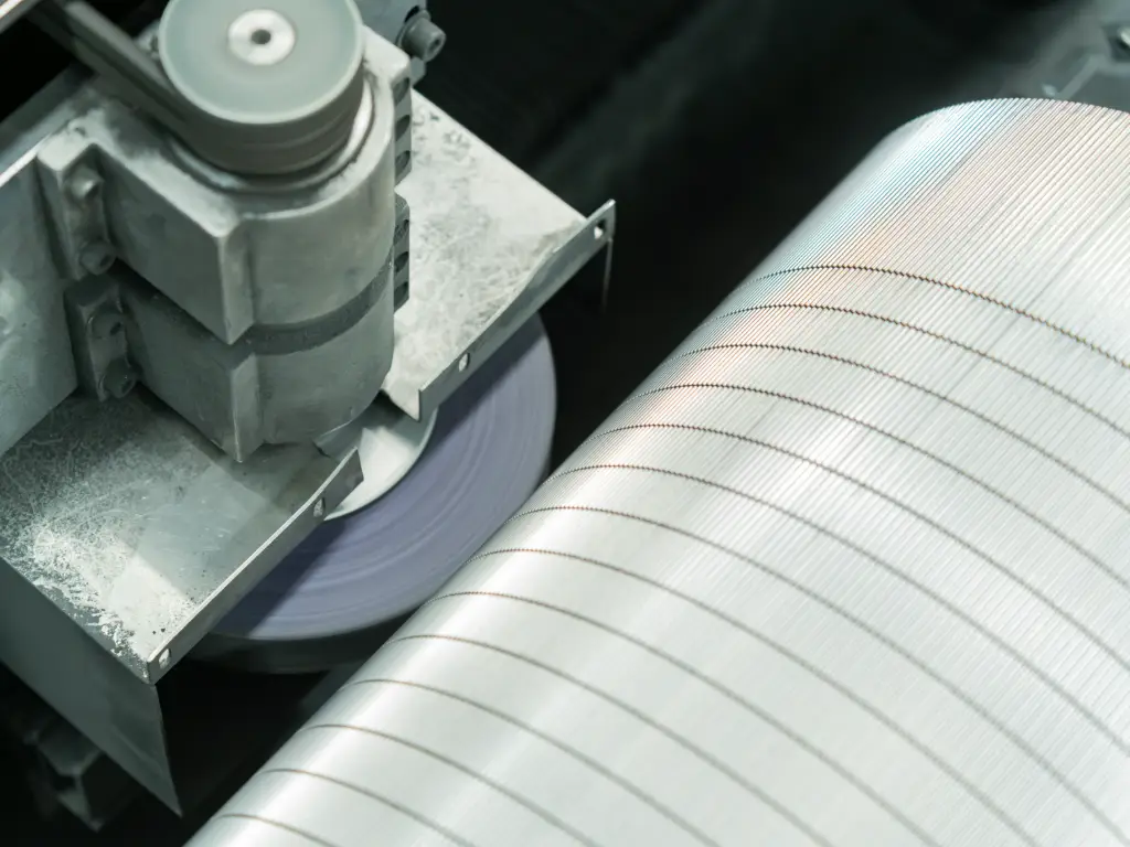 Detailed view of the polishing process transforming a rough roll surface to a high-shine finish.