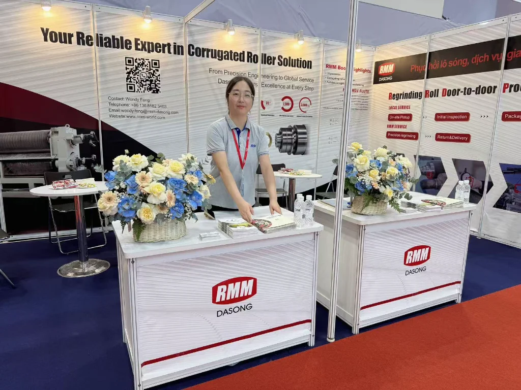 RMM's booth reception desk at Vietnam Print Pack 2025, with a salesperson organizing materials