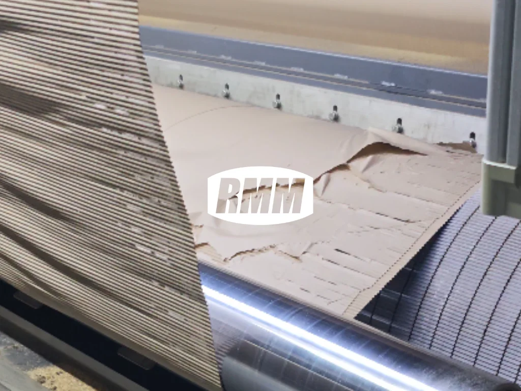 Broken corrugated paper on production machinery with RMM logo overlay