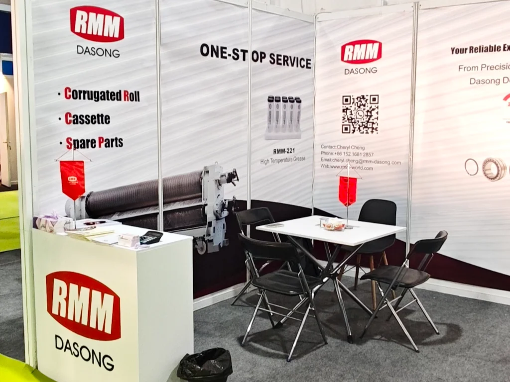 RMM 's booth at Agro Pack Iraq Exhibition (booth EN-108), featuring corrugated packaging products like corrugated rolls, cassettes, and spare parts, with a one-stop service display.