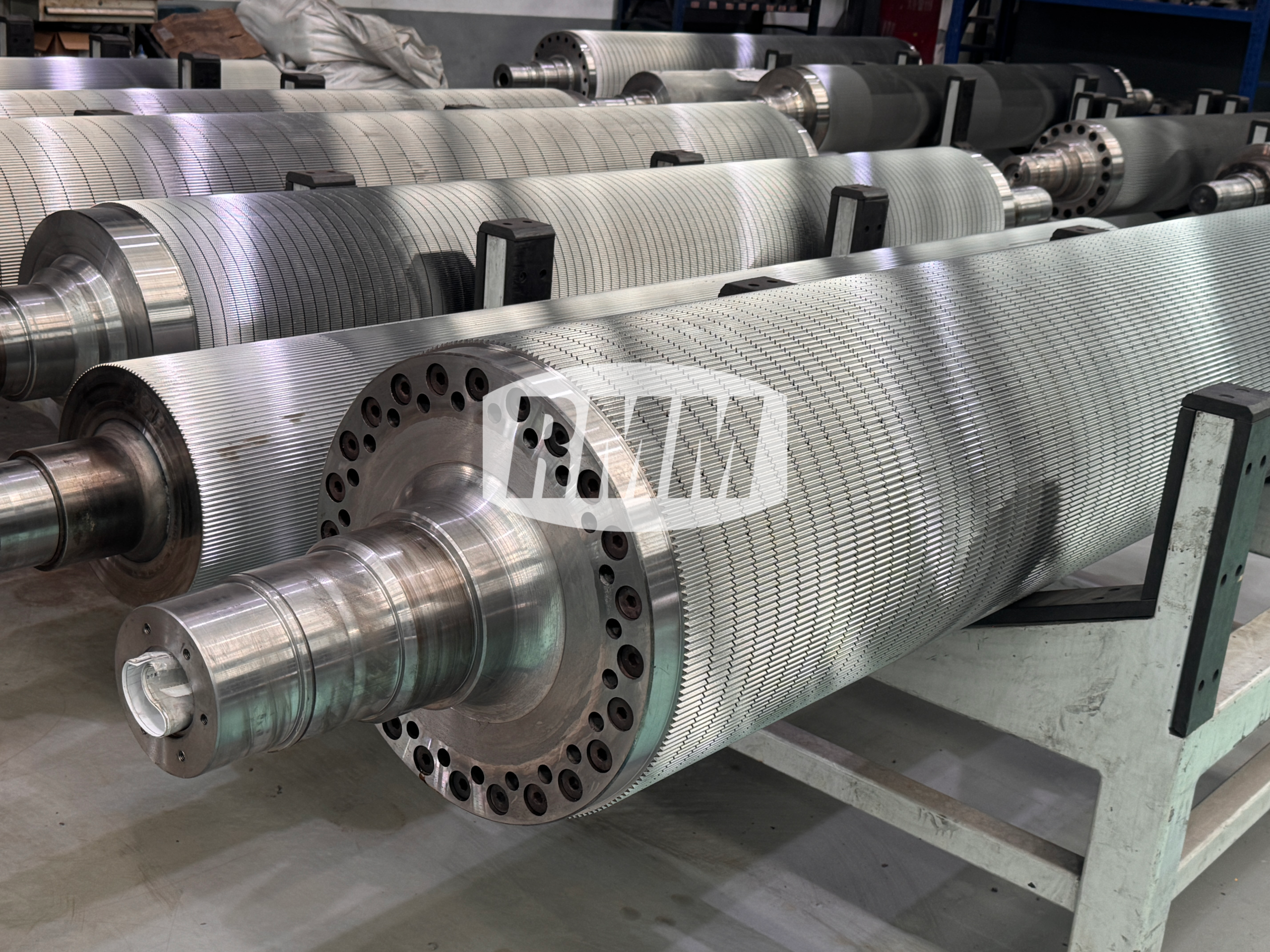 Multiple custom tooth-profile corrugating rolls are neatly arranged.