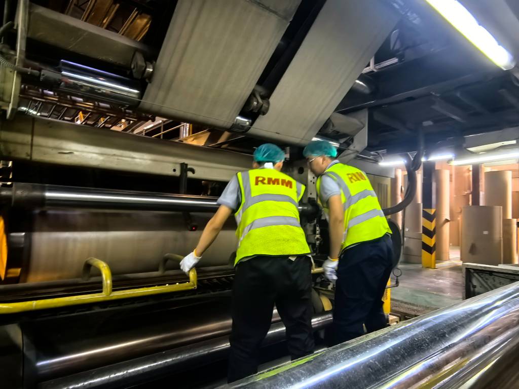 Technician inspecting a corrugating machine for vibration