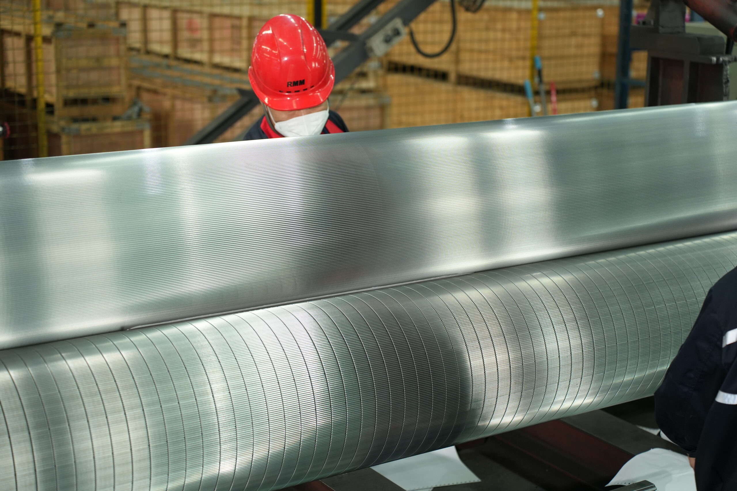 A close-up of two corrugating rolls meshing together