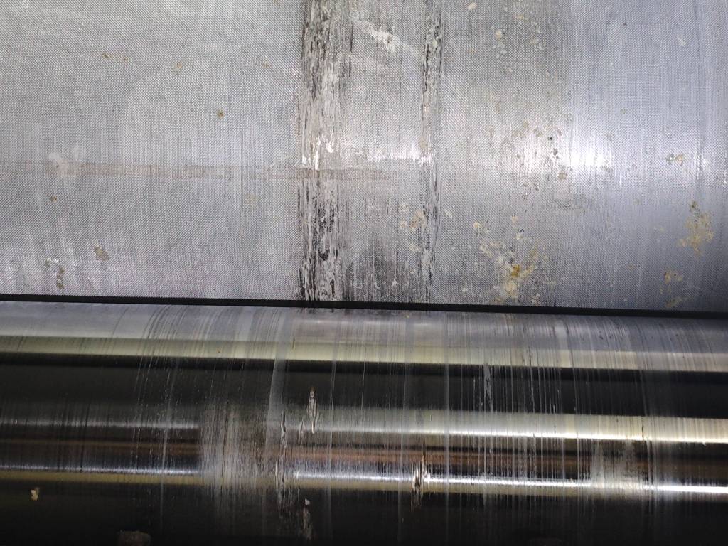 Damaged glue roll and doctor roll with worn surface affecting adhesive application in corrugated cardboard manufacturing.
