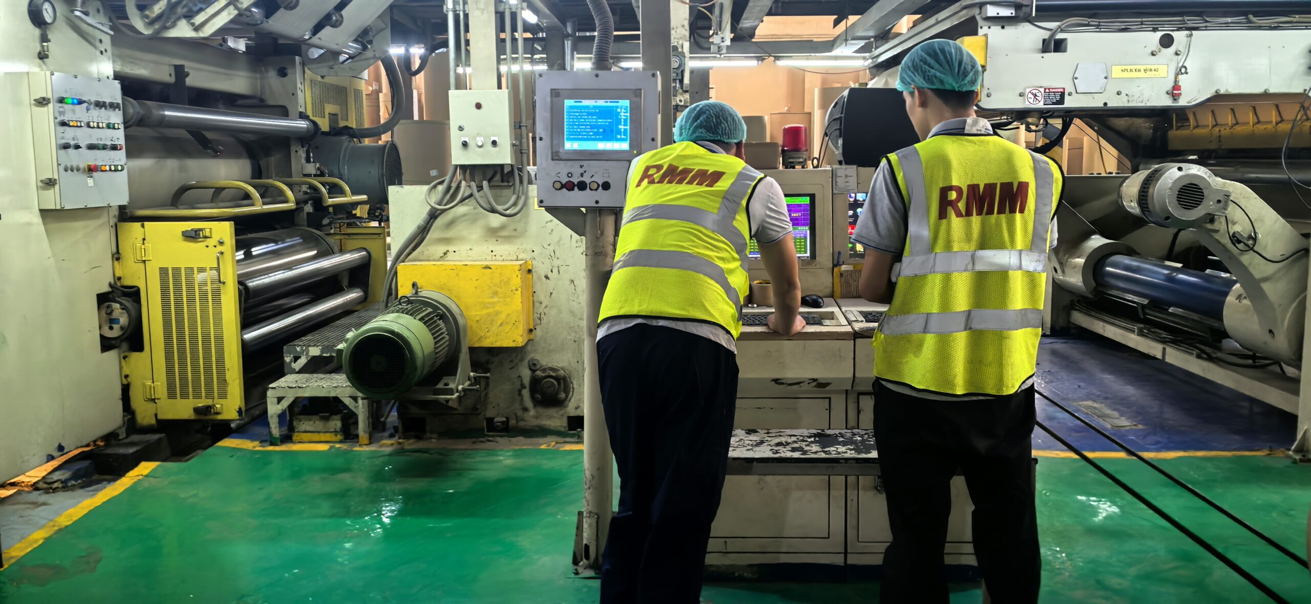Operator adjusting roll pressure settings on single facer control panel